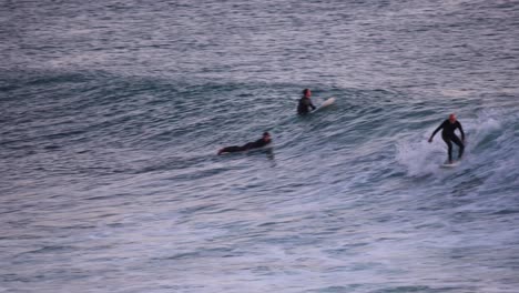 Surfista-Aficionado-Monta-Olas-Cristalinas-En-Una-Divertida-Tabla-De-Surf-Entrando-En-La-Noche-En-Estoril,-Cascais