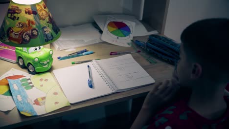 child doing homework at night on his desk