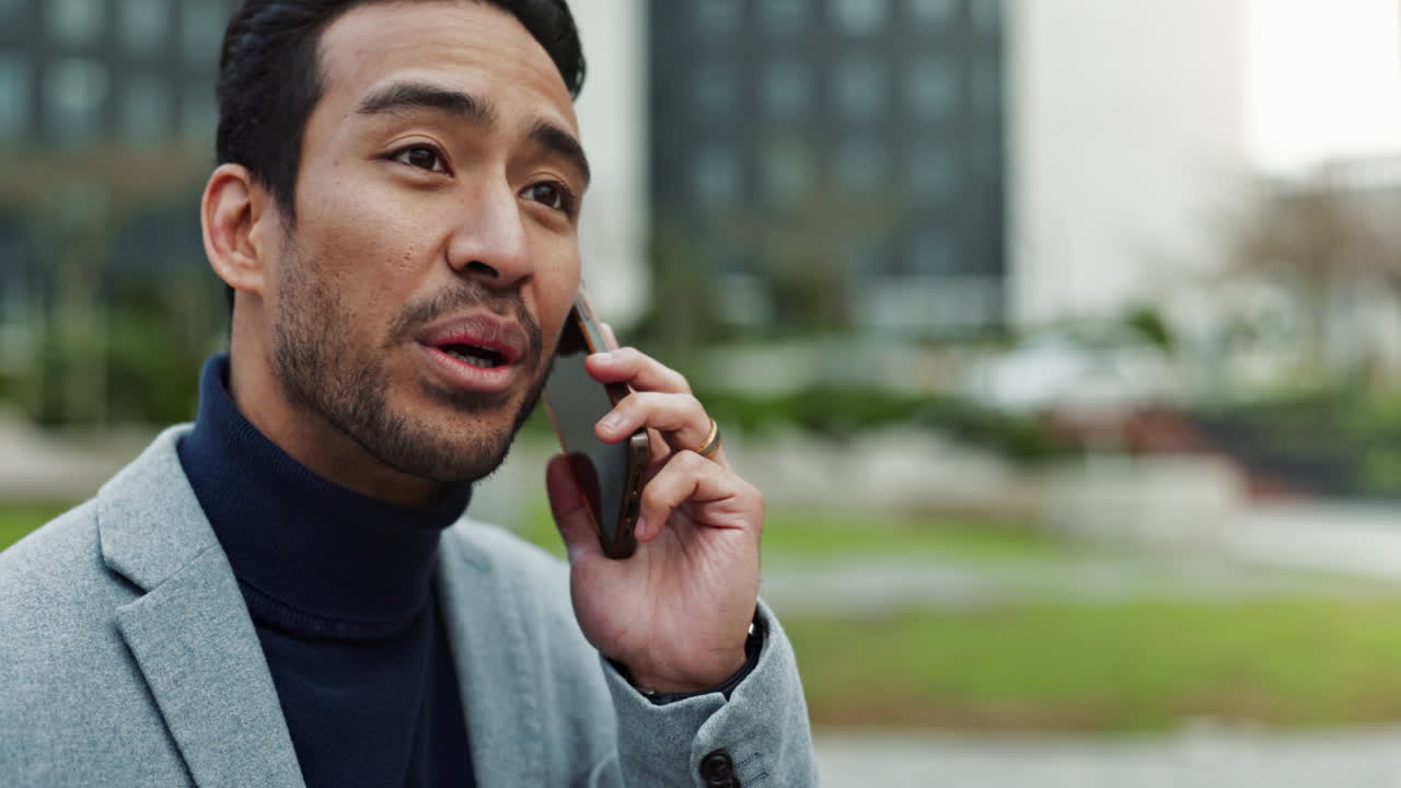 슈트를 입은 남자가 미소 짓고 전화로 얘기하고 있다.