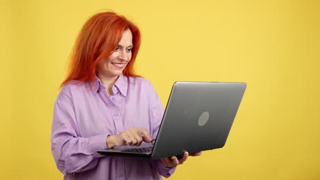 happy woman with red hair using a laptop
