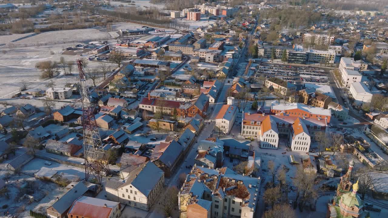 vista aérea del casco antiguo de kuldiga, casas con tejas rojas, día soleado de invierno, destino de viaje, amplia toma de drone moviéndose hacia adelante, inclinándose hacia abajo