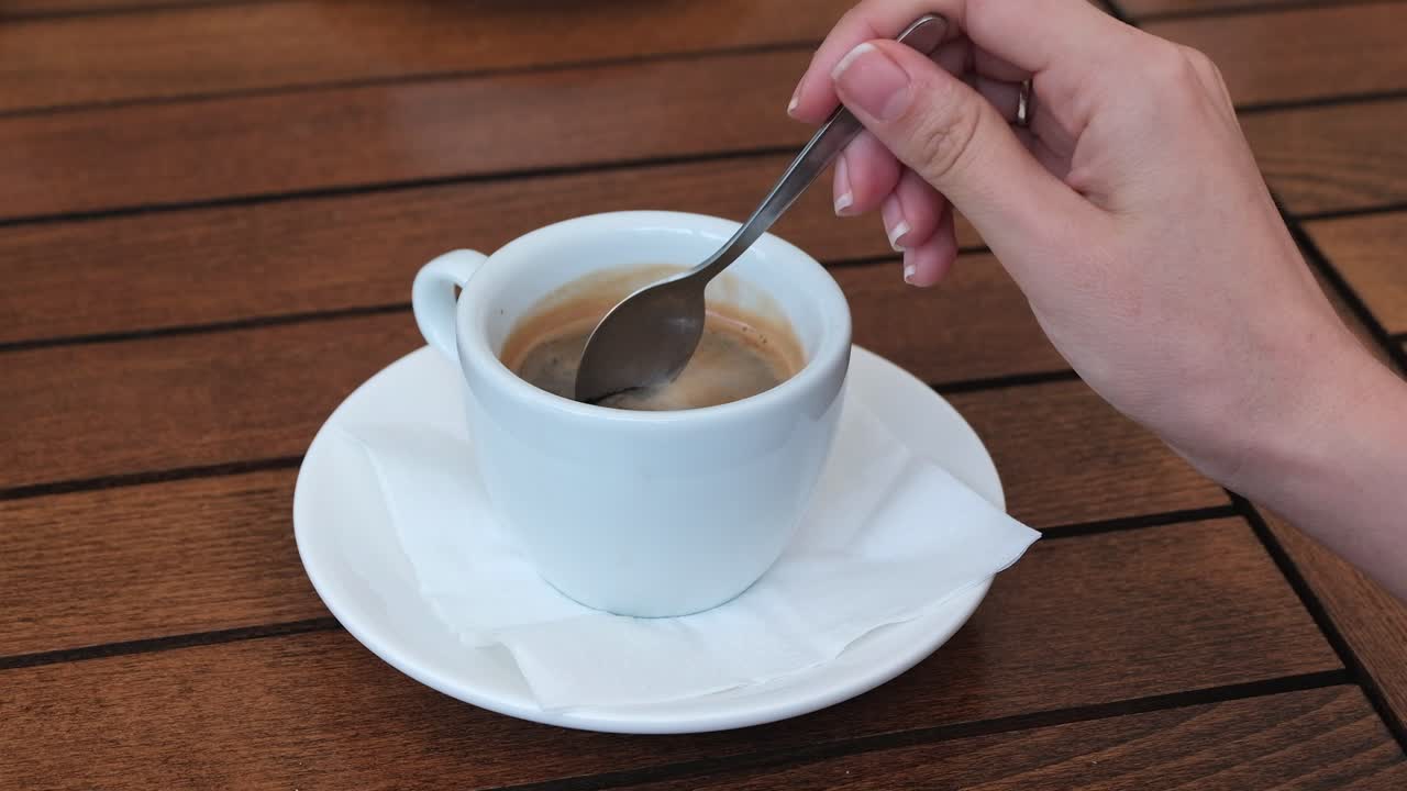 Young man drink from a bamboo straw ice coffee near a park lake