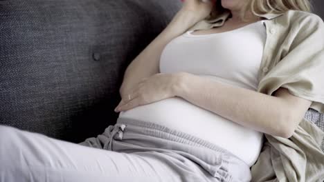 smiling married pregnant woman talking on smartphone