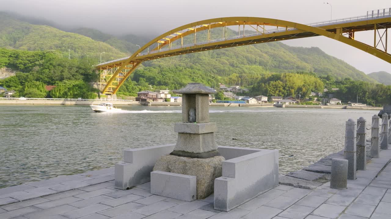 Small shinto shrine at local Japanese harbor with boat in distance