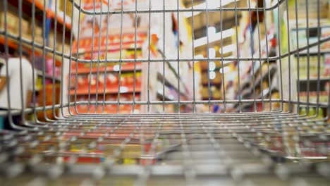 no hay papel higiénico y personas que usan máscaras faciales debido al miedo al coronavirus en una tienda - punto de vista del carrito de compras