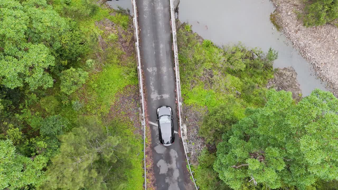 vista aérea de un coche en un puente forestal