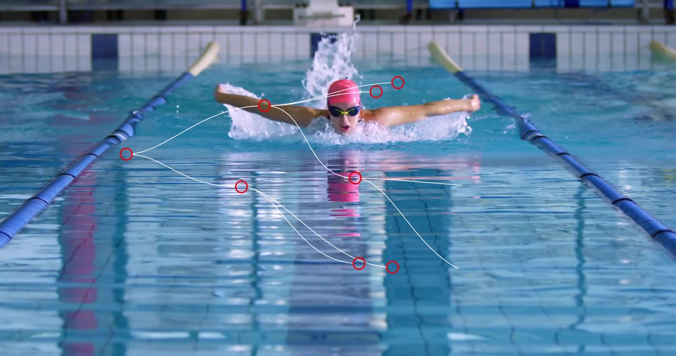 Schwimmerin beim Schmetterlingsschwimmen, hebt Kopf zum Einatmen und erzeugt Wasserbögen im Fitness-Guide