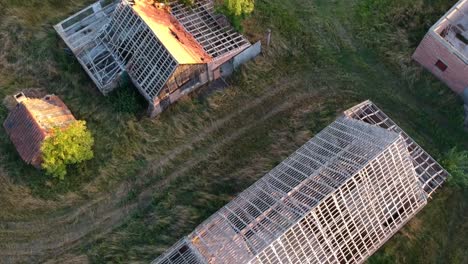 deslizándose por encima de los edificios agrícolas deteriorados al atardecer, sin techo