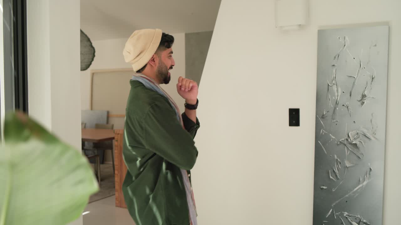 Man is carrying panel into living area after sliding door opens, positioning it for display