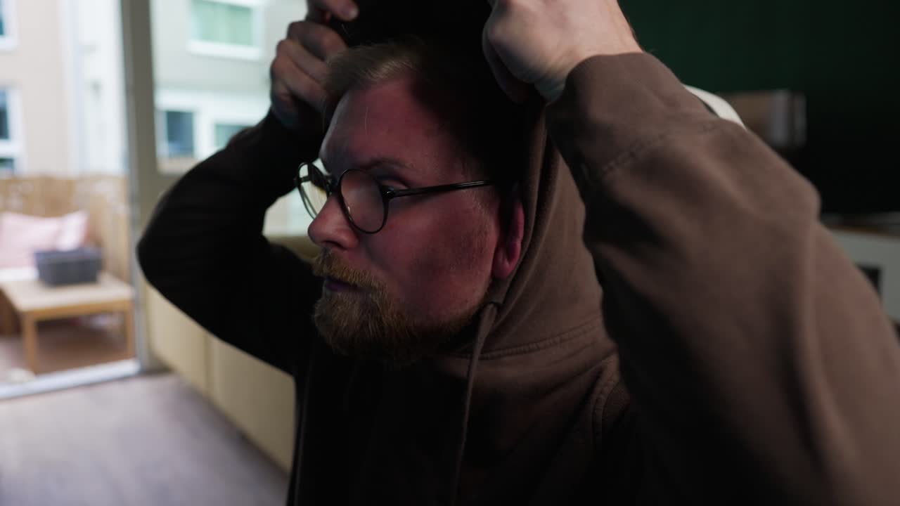 스트리밍 - 남자는 카메라, 콘텐츠 제작자, 슬로우 모션 앞에서 후드티를 입습니다.