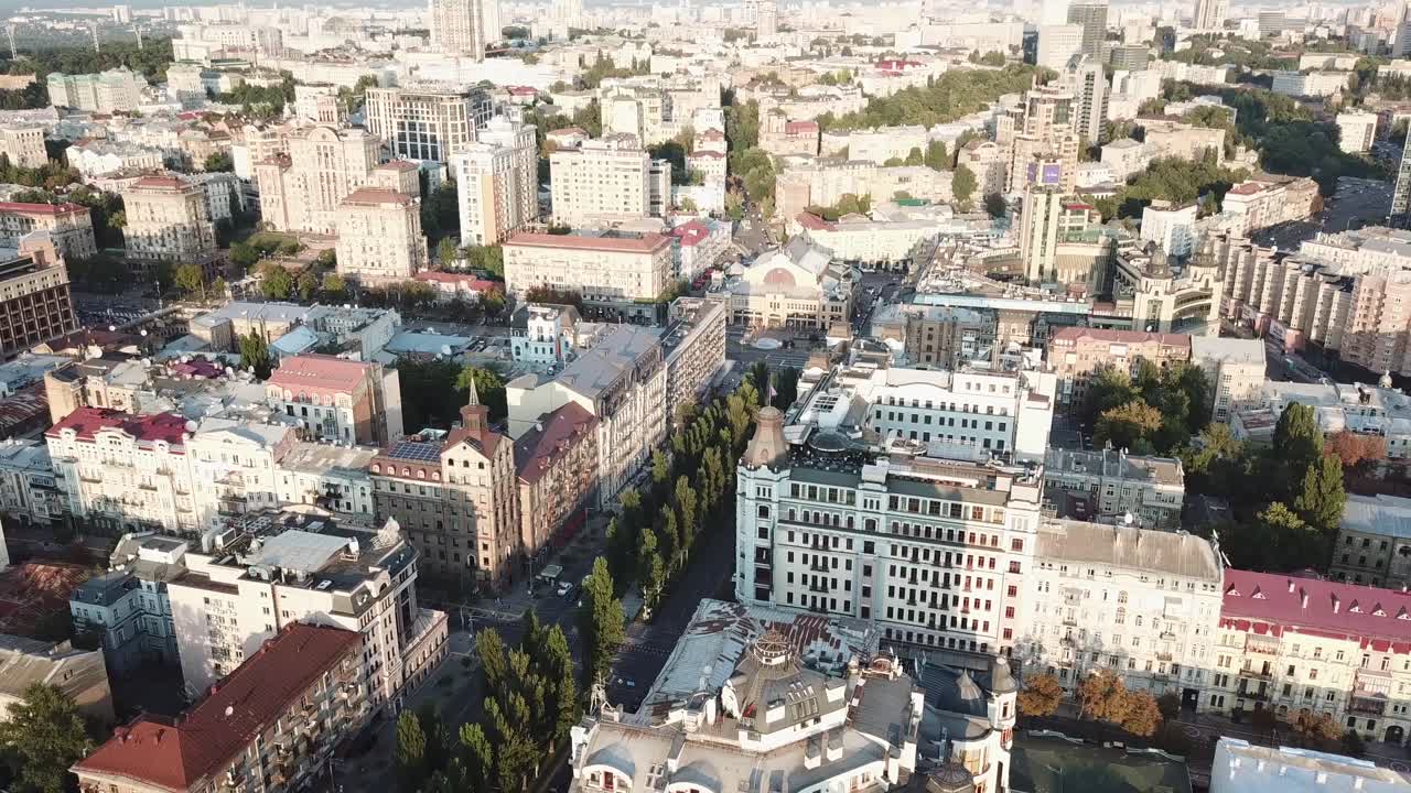 Ukraine, Kyiv, Drone Footage of a city view on a sunny day, camera turns from left to right over buildings, parks and streets from high and above, ends at the stadium, no people.