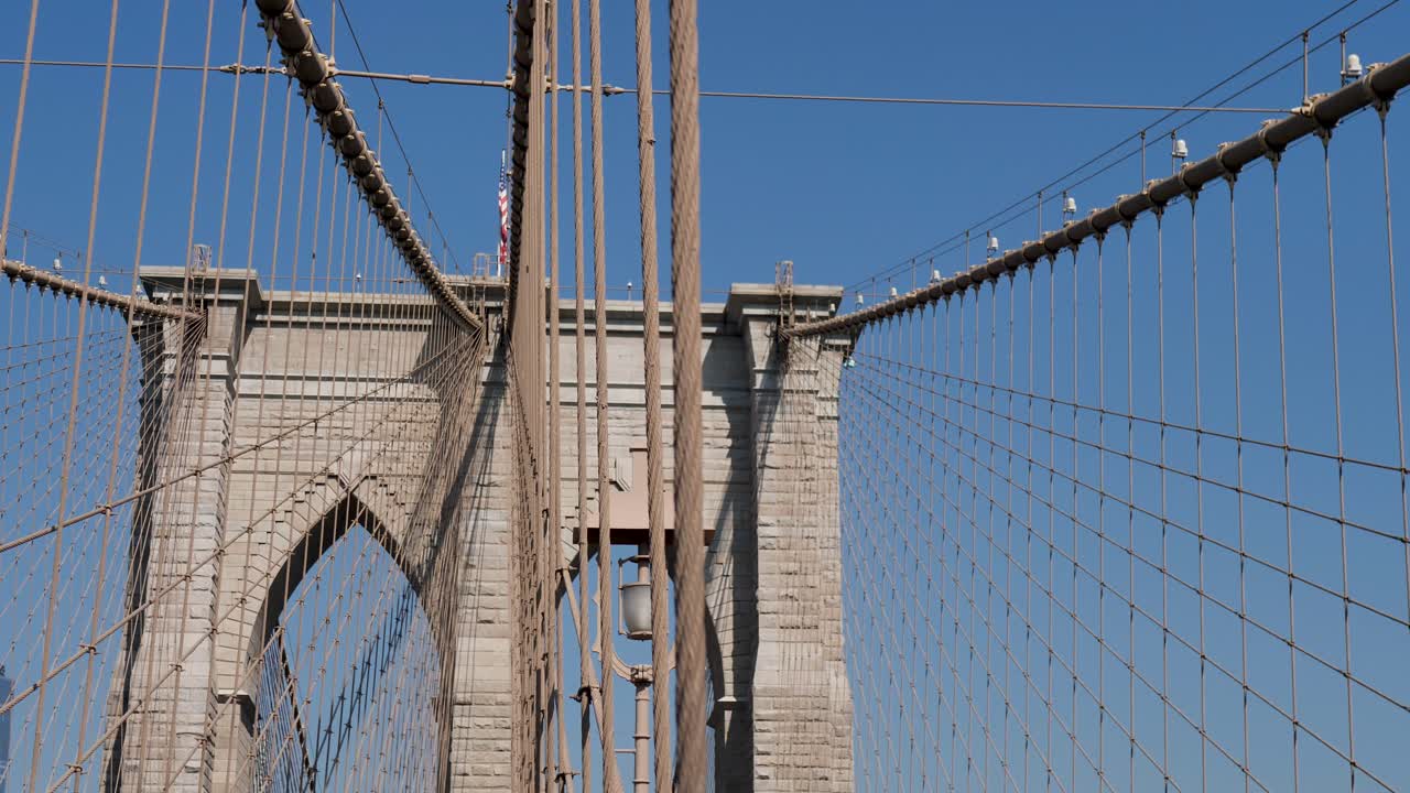 Panoramica al rallentatore degli archi dell'iconico Ponte di Brooklyn, New York City. CBD Manhattan, barriera, ingegneria, infrastruttura, turismo, USA, America, paesaggio, Brooklyn.