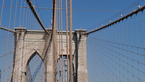 slow motion pan of building arches of the iconic brooklyn bridge new york city cbd manhattan barrier engineering infrastructure tourism usa america landscape brooklyn