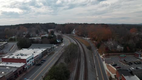 aerial of small town railroad tracks at sunset during the fall