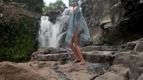 woman by waterfall in a tropical forest