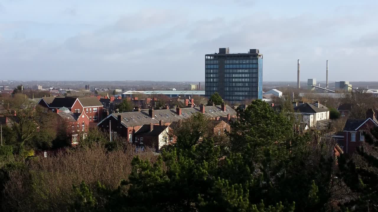 vista aérea sobre los árboles del parque al paisaje de la ciudad industrial con el horizonte azul del rascacielos, merseyside, inglaterra