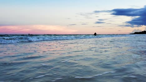 people enjoying the sunset in the caribbean with relaxing waves