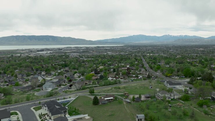 Pleasant Grove nella contea di Utah, Stati Uniti, all'interno della valle locale, che mostra la griglia residenziale che scende verso il lago e le montagne occidentali lungo il margine del bacino, terre ancestrali del popolo Ute, vista aerea