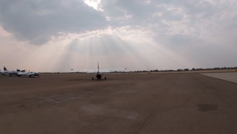 small white aircraft prepares to enter the runway at an airport for takeoff