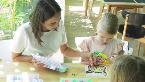 mother and daughter beading together