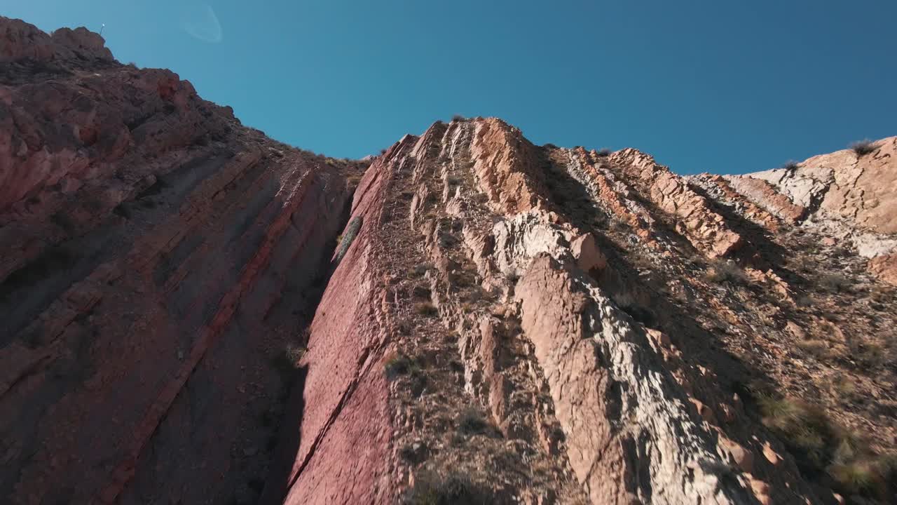 tiro planeado de un dron que se eleva cerca de una colina alta que revela impresionantes vistas a las montañas, norte de argentina