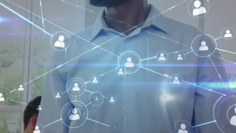 red de iconos de perfil contra un grupo de diversos empresarios que usan dispositivos electrónicos en la oficina