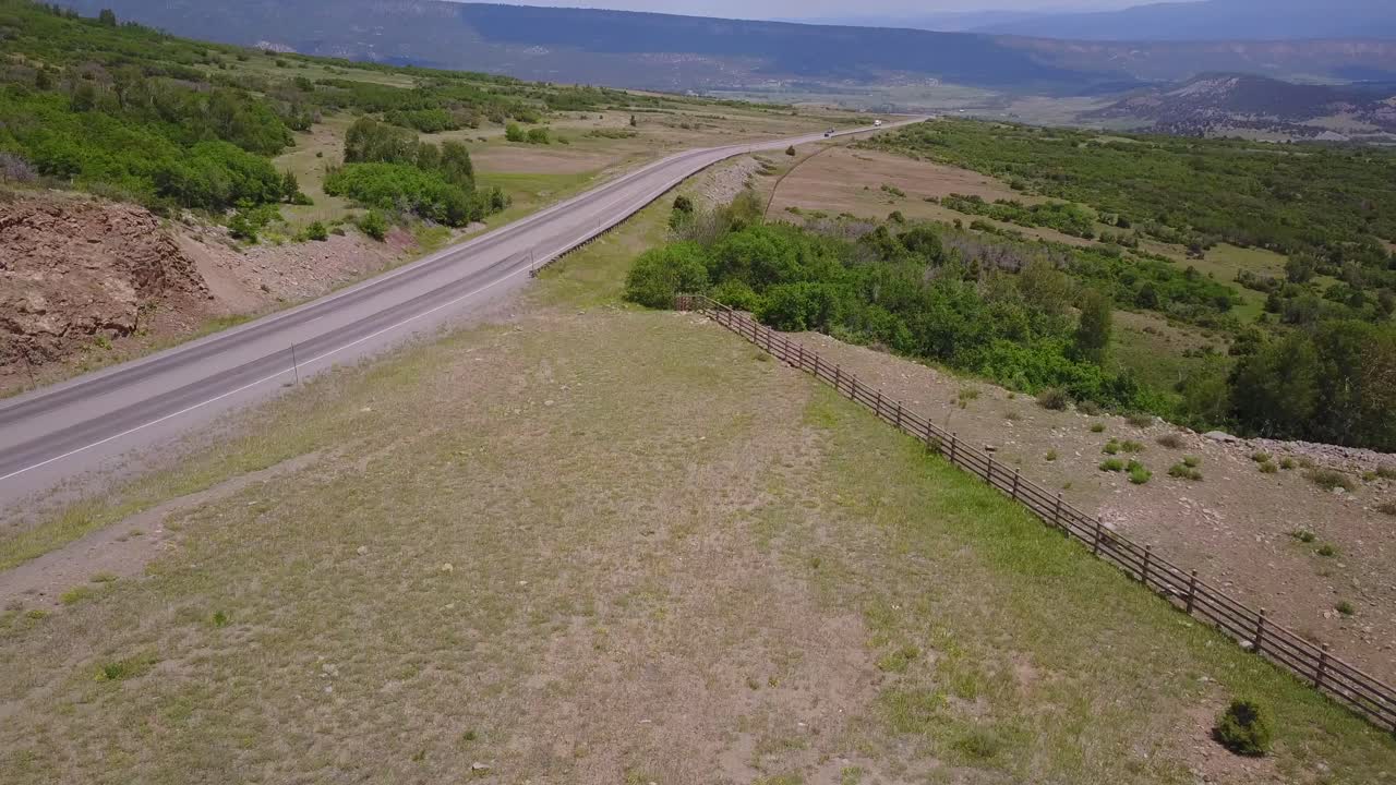 Aerial: Dallas Divide Highway on gentle hillside on clear, sunny day