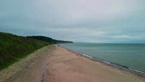 Imágenes-De-Drones-Sobre-Una-Vasta-Playa-De-Arena-En-Un-Océano-En-Calma