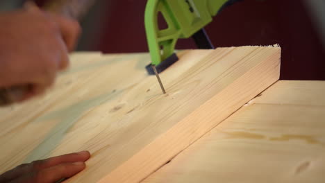 hand hammering a nail into wood using clamps