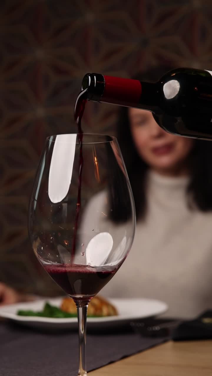 Versare vino rosso in un bicchiere al ristorante