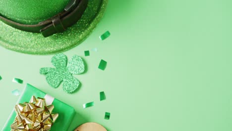 video de la hoja de trébol verde de san patricio, presente y sombrero con espacio de copia en fondo verde.