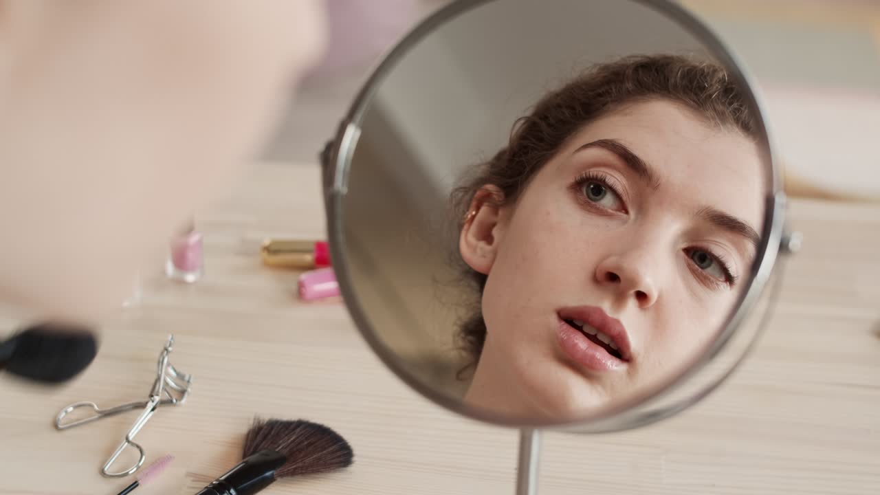 joven mujer caucásica usando pincel de polvo