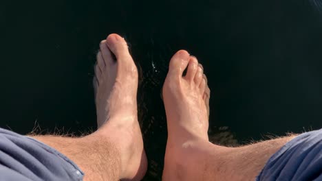 first-person perspective view of relaxing feet on the lake water