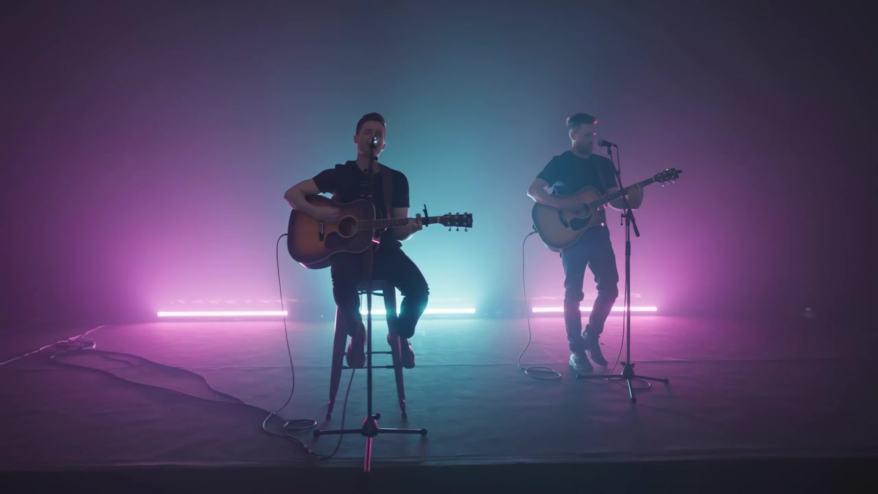 En optræden starter med en akustisk duo i sorte T-shirts, der synger på en lille scene med guitarer, mikrofoner og LED-tåge.