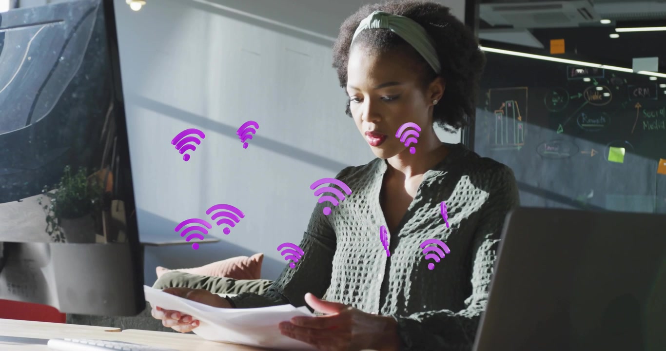 Business woman scanning reports at desk, purple Wi-Fi icons indicating data upload then typing info