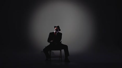 mysterious silhouette of man in suit and fedora under spotlight