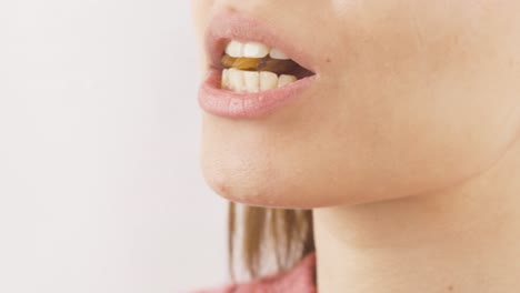 primer plano de una mujer comiendo pasas, frutas secas.