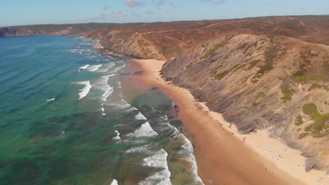 perfect view landscape of the ocean by the rocky mountain in the coast of algarve, portugal district of faro under blue sky. - aerial drone shot