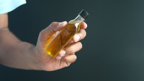 hand holding a small bottle of oil