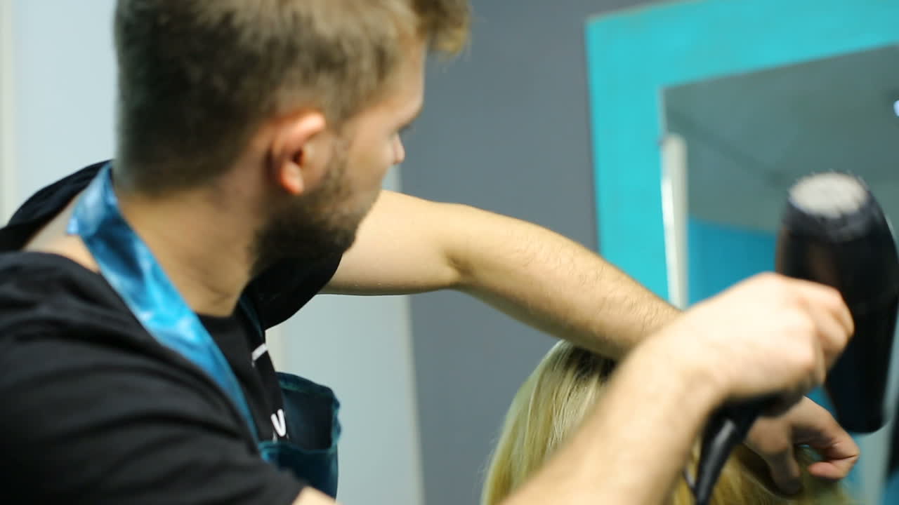 Professional stylist working with client. Professional hairdresser dyeing hair of woman at salon