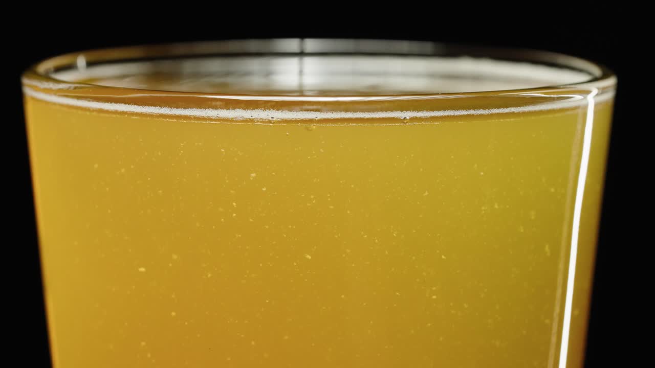 cerveza ipa en un vaso frío, fondo negro de vista frontal