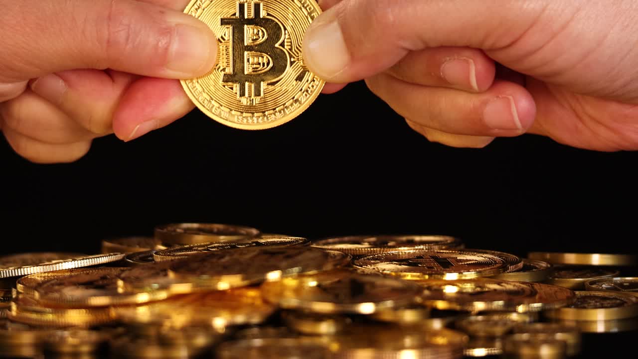 Two hands struggle over a gold bitcoin coin above stacked coins, dramatic lighting, close-up