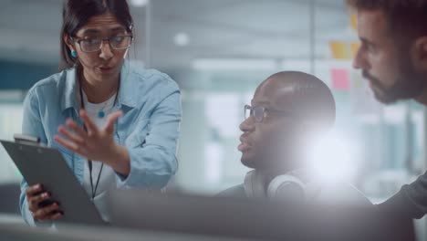 grupo diverso de profesionales enérgicos que se reúnen en una oficina moderna: tormenta de ideas programadores de ti usan computadora juntos, hablan de estrategia, discuten análisis ingenieros de software desarrollan programas de aplicaciones primer plano