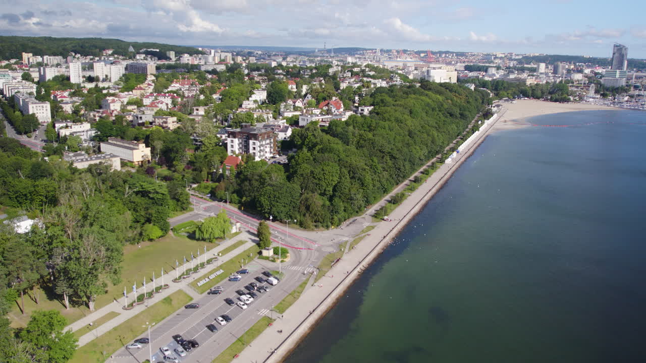 폴란드 그디니아(gdynia)에 무성한 잎이 있는 나무로 둘러싸인 건물이 있는 해변 대로의 공중 전망