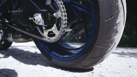 Close-up-shot-of-the-lower-part-of-a-motorcycle-with-focus-on-the-back-wheel-chain