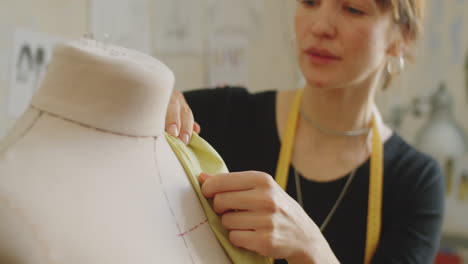 seamstress draping fabric on dress form