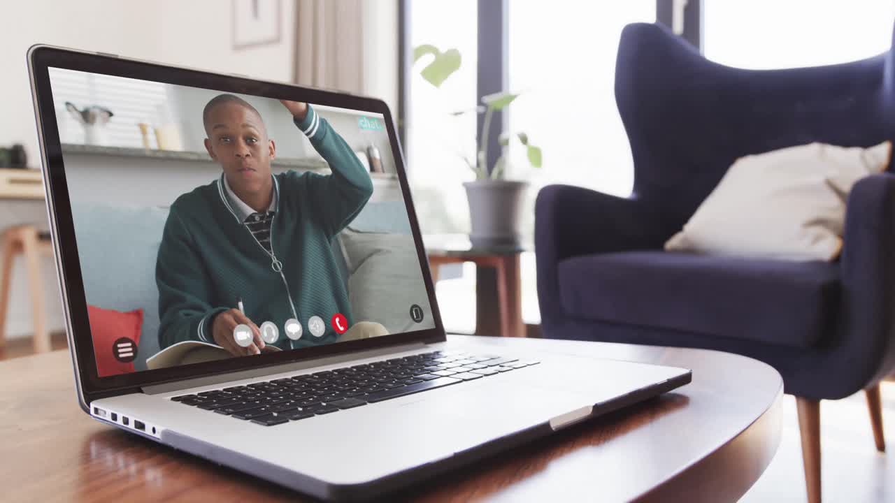 African american male student having class on laptop video call and raising hand in slow motion
