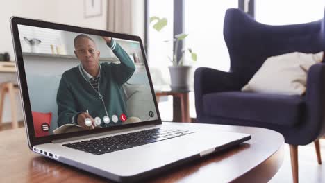 African-american-male-student-having-class-on-laptop-video-call-and-raising-hand-in-slow-motion