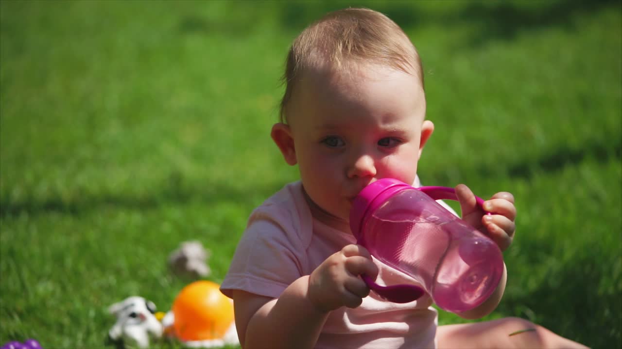 Bambino che beve acqua all'aperto