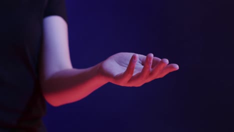 hand of asian woman, touching virtual screen on blue background, copy space, slow motion